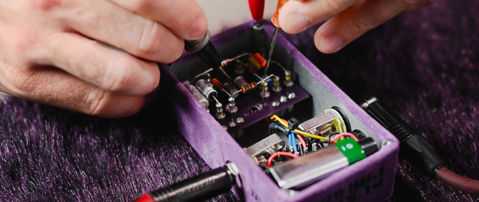 image of hands installing electronics into a JAM bass pedal