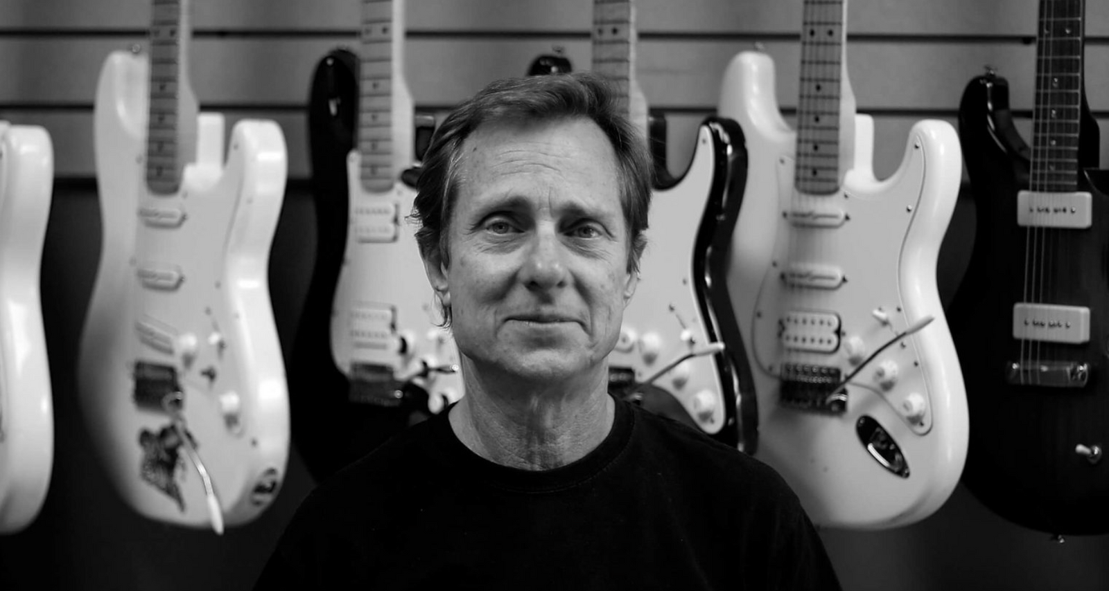 Photo of Lindy Fralin Bass Pickups in front of a wall of instruments