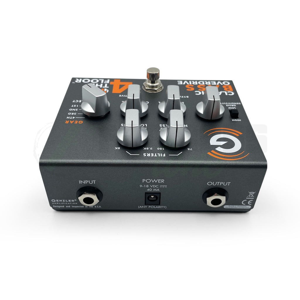 Rear view of the Genzler 4 on the Floor Overdrive Bass Pedal, showing all the control knobs, the Drive Select, the Drive Sensibility switch and the stomp button, in addition to the input, output and power which are located on the rear panel.