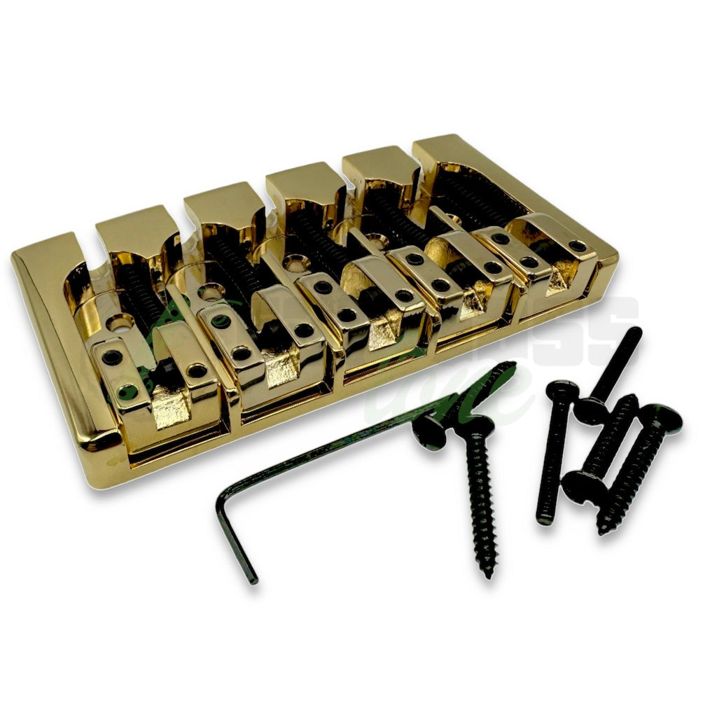 photo of the gold aluminum version of the Hipshot A Style Fender® Mount Bass Bridge for 5 string showing the included 5 mounting screws, allen wrench and extra intonation screw