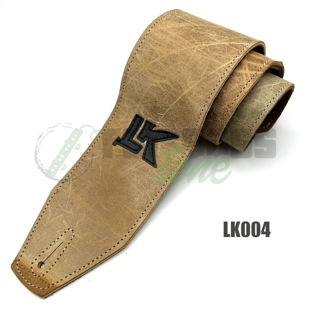 A light brown LK Straps Leather Bass Strap with black logo
