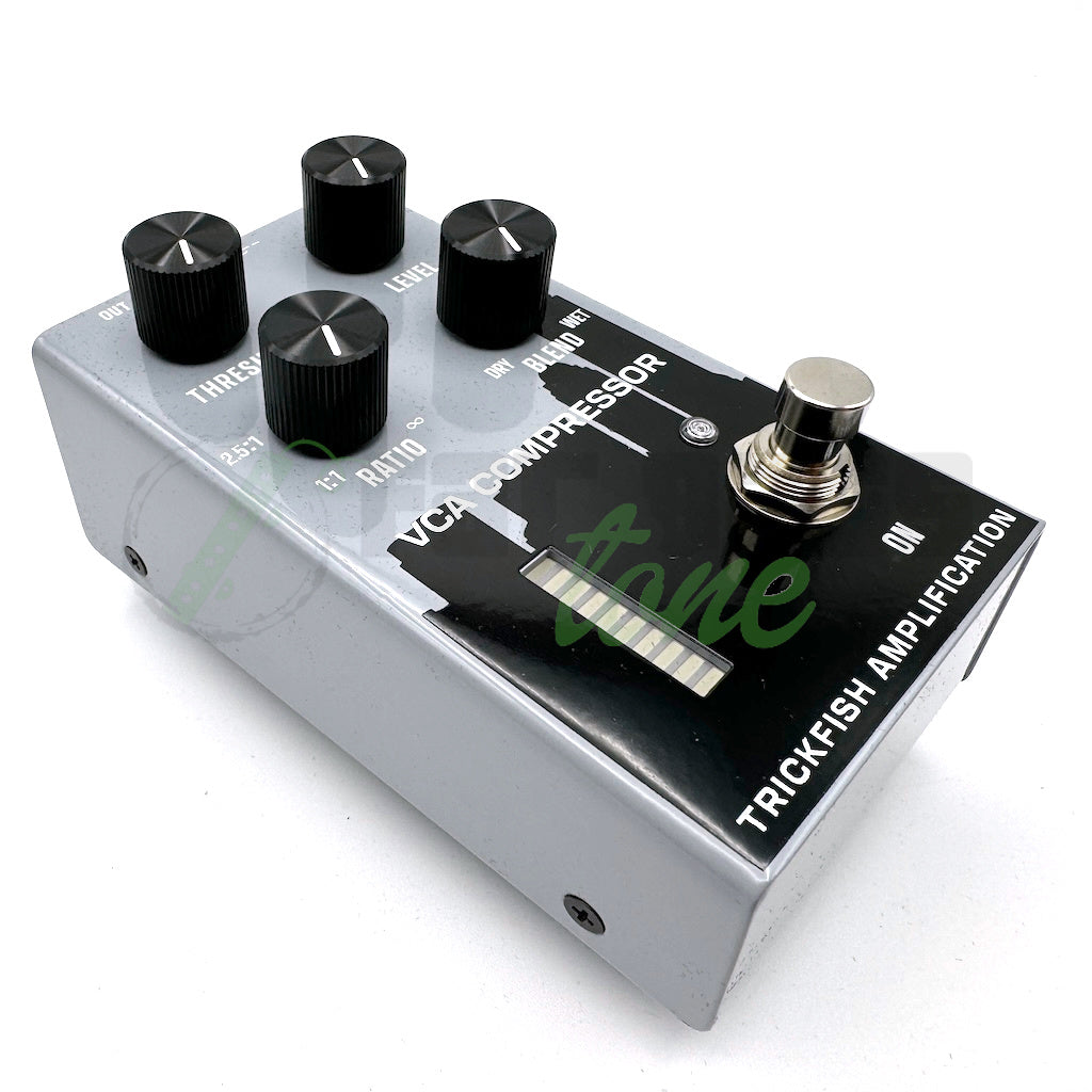 front left angle photo of the Trickfish VCA Compressor Bass Pedal showing the labling of the pedal and black skyline silhoutte